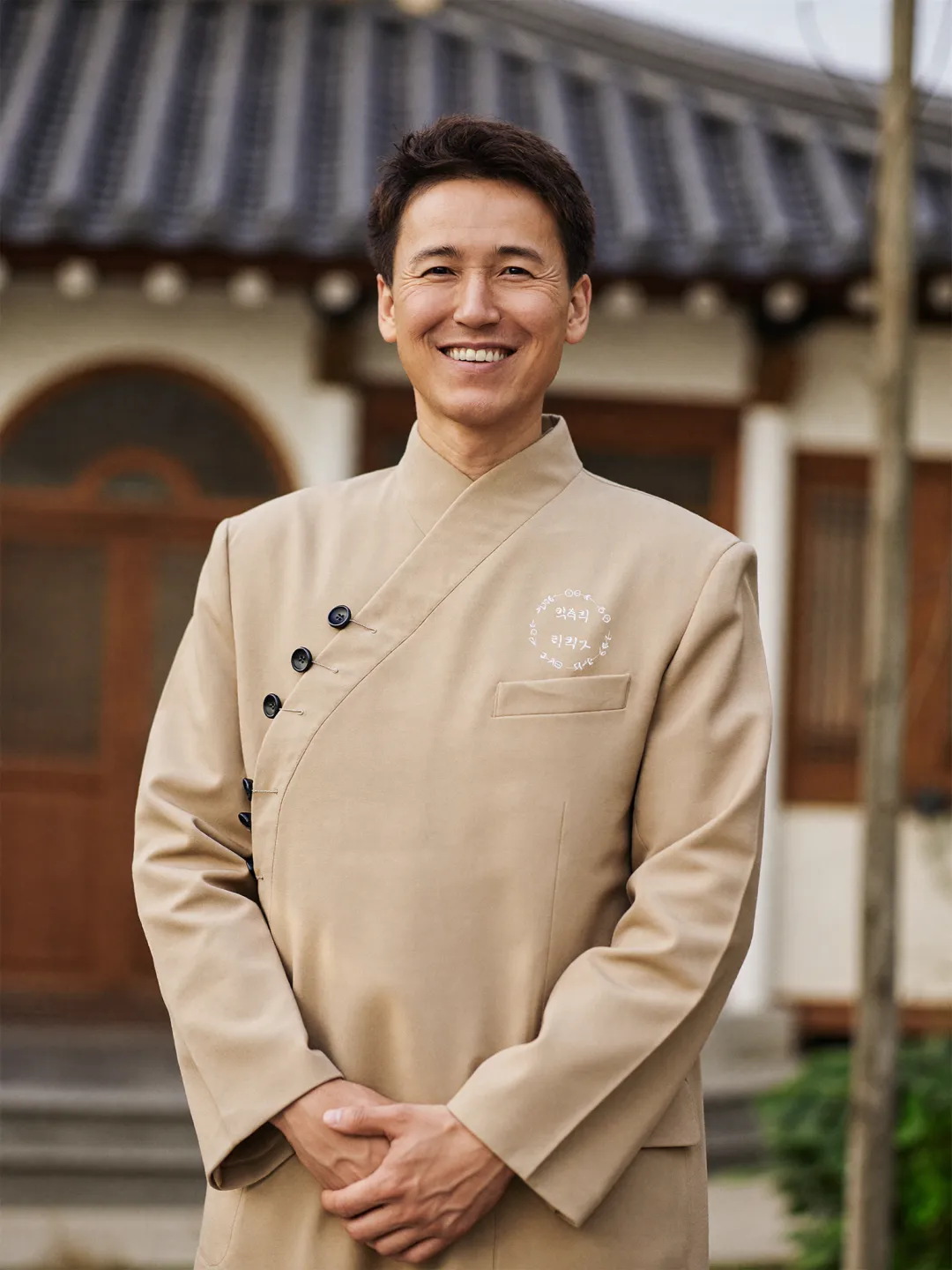 한옥을 배경으로 개량한복 코트를 입고 온화하게 미소 짓는 이서준 대표원장
